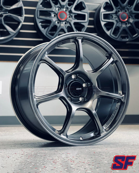 Black alloy wheel with a blurred background featuring more wheels.