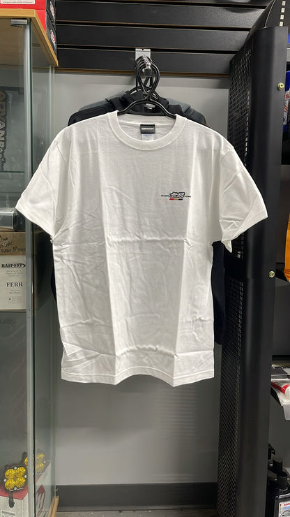 White t-shirt with a small logo on a hanger against a black background